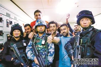 被困20多个小时的外籍船员获救后，兴奋地与我海军护航官兵合影。本报特约记者 李 维摄
