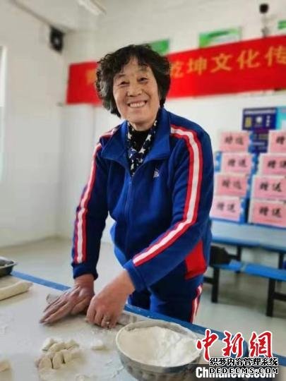 图为21日志愿者擀饺子皮儿。　钟欣 摄