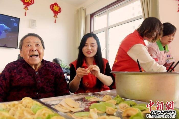 冬至来临，兰州志愿者队伍与托老所老人们围着桌子，一边包饺子，一边拉家常。　韦德占 摄